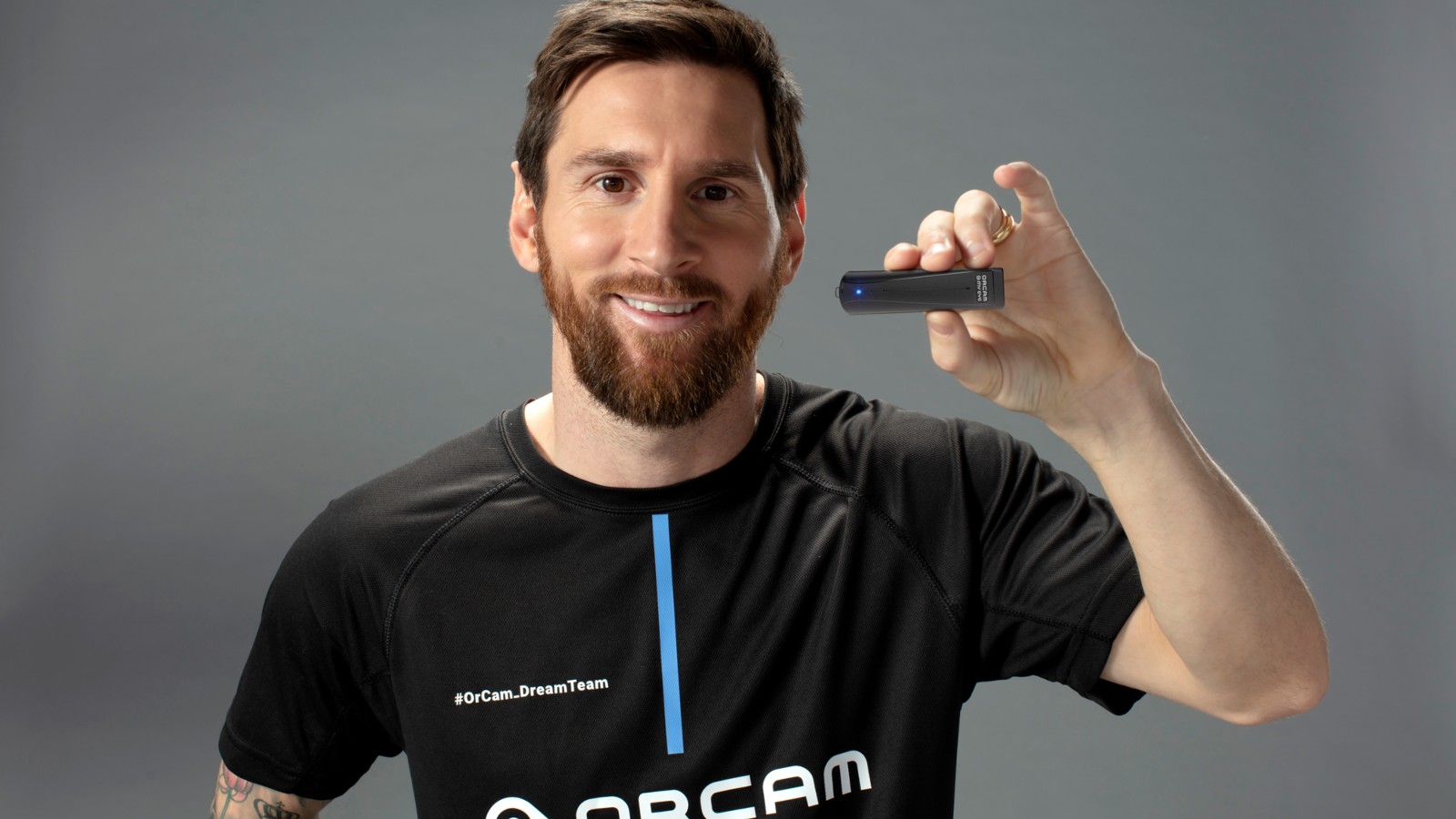 Lionel Messi holding the OrCam MyEye wearable device that reads text aloud. Photo courtesy of OrCam