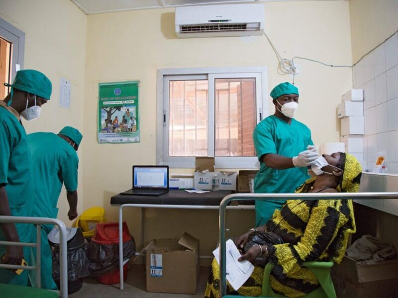 A healthcare worker performs a nasal swab as he tests a woman for COVID-19 in Bamako, Mali.