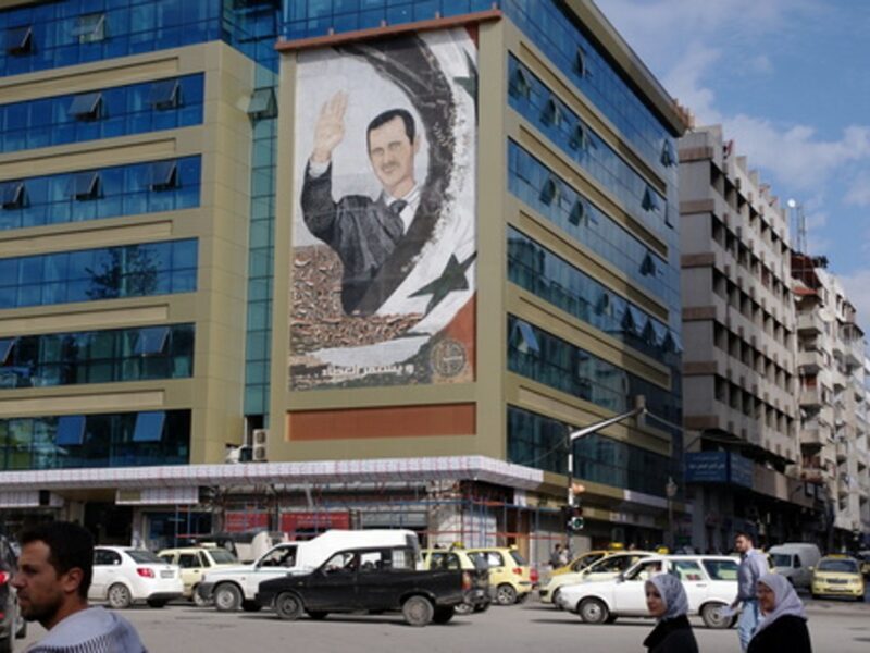 A mural featuring Syrian President Bashar Assad in Latakia, Syria. Credit: Emesik via Wikimedia Commons.