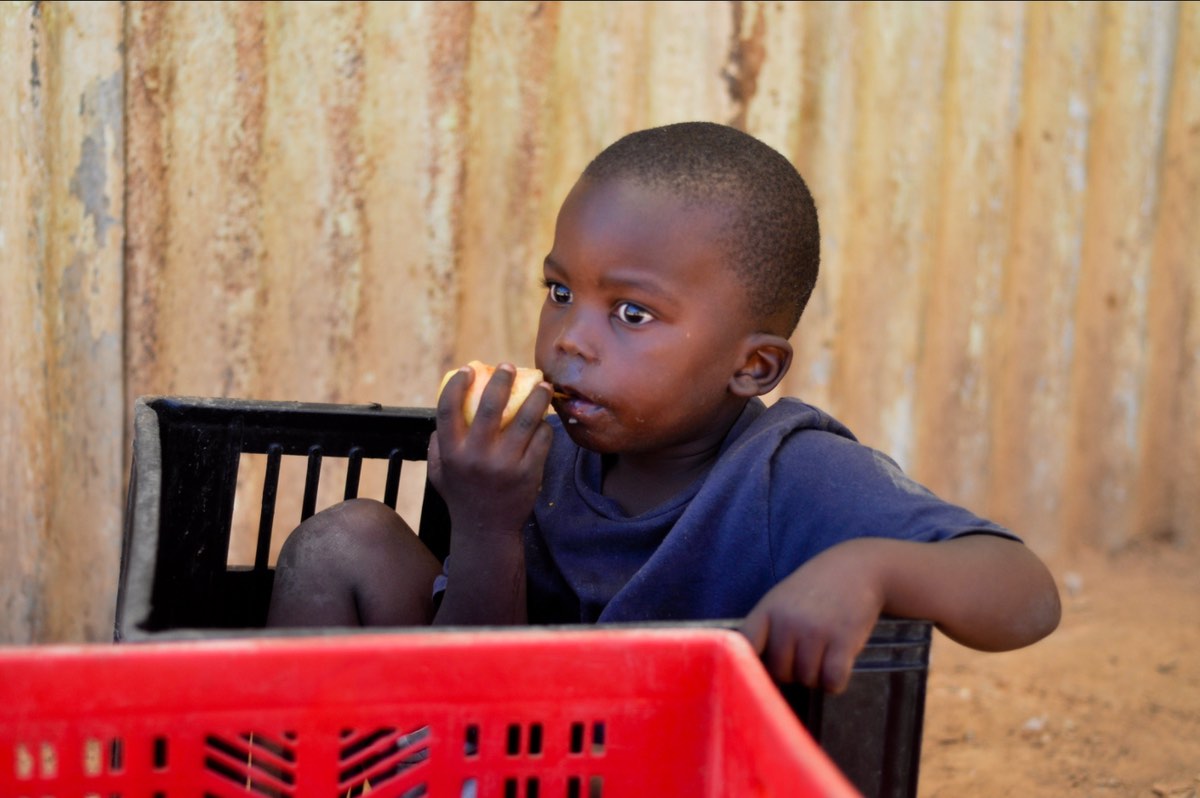 Child eating a fruit, by Megan Trace, Flickr