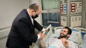 Israeli Prime Minister Naftali Bennett visits one of the civilians wounded in the deadly terrorist attack in Tel Aviv on April 7, 2022, at Tel Aviv's Sourasky Medical Center on April 9, 2022. Credit: Prime Minister's Office.