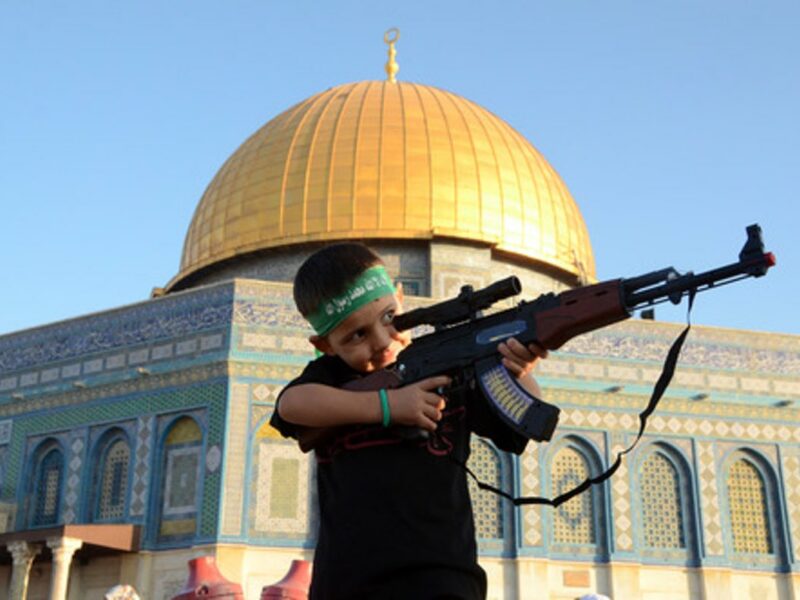 A Palestinian boy wearing a Hamas headband aims a toy gun during a rally after prayers at the Al-Aqsa mosque in Jerusalem, July 28, 2014. Credit: Sliman Khader/Flash90.