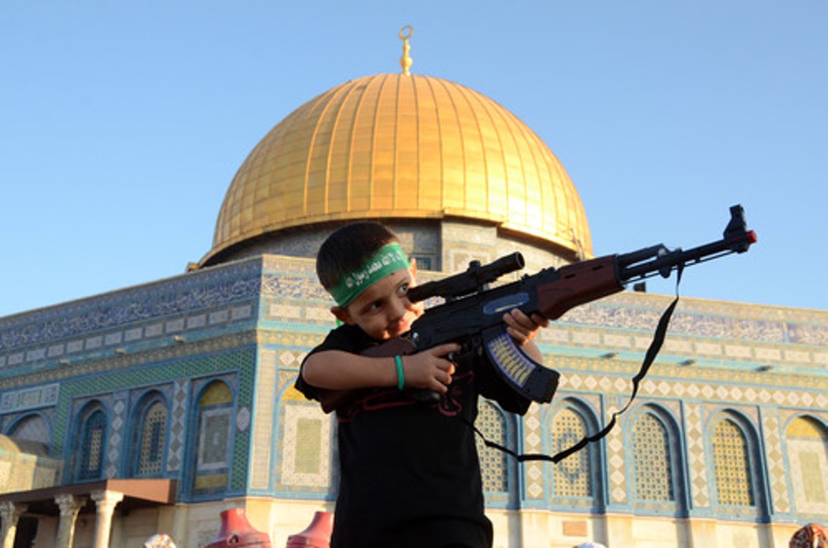 A Palestinian boy wearing a Hamas headband aims a toy gun during a rally after prayers at the Al-Aqsa mosque in Jerusalem, July 28, 2014. Credit: Sliman Khader/Flash90.