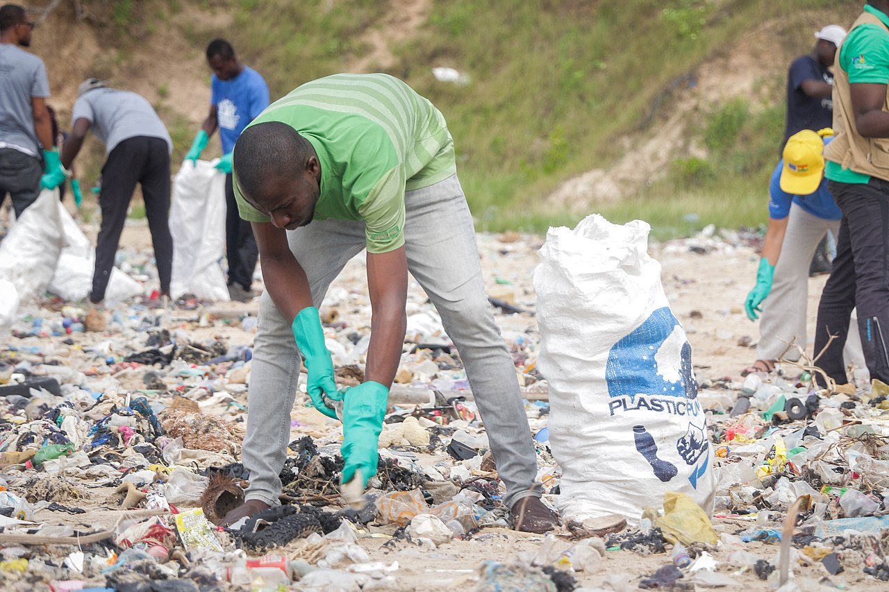 A man, collecting plastic waste at the beach during cleanup exercise in Ghana. Source: Fquasie, commons.